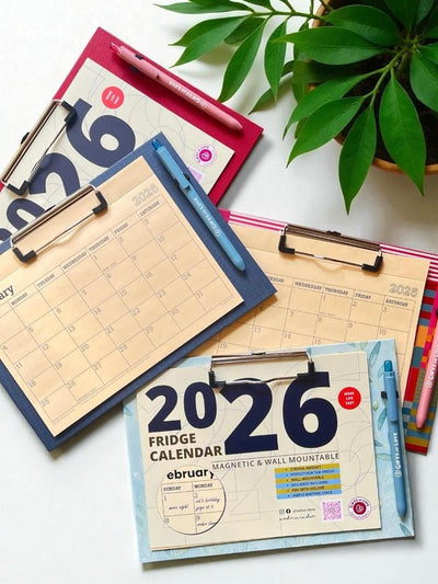 Collection of 2026 magnetic calendar on a white surface with a plant in the background