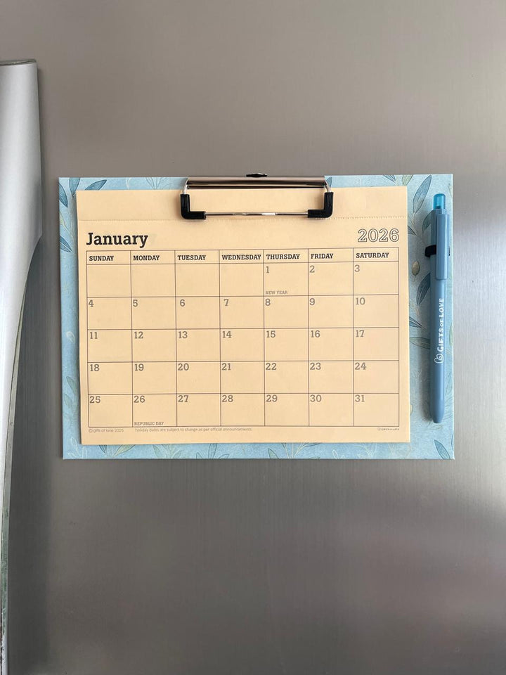 2026 Magnetic  Calendar on a  refrigerator with a pen on a blue decorative mat.