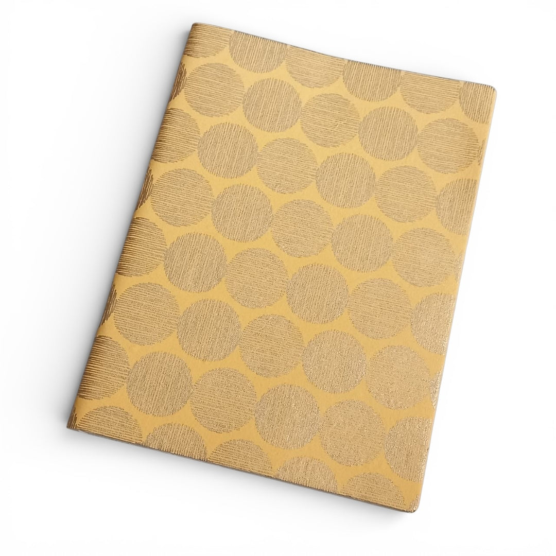 Notebook with gold circular sunrise pattern on a white background