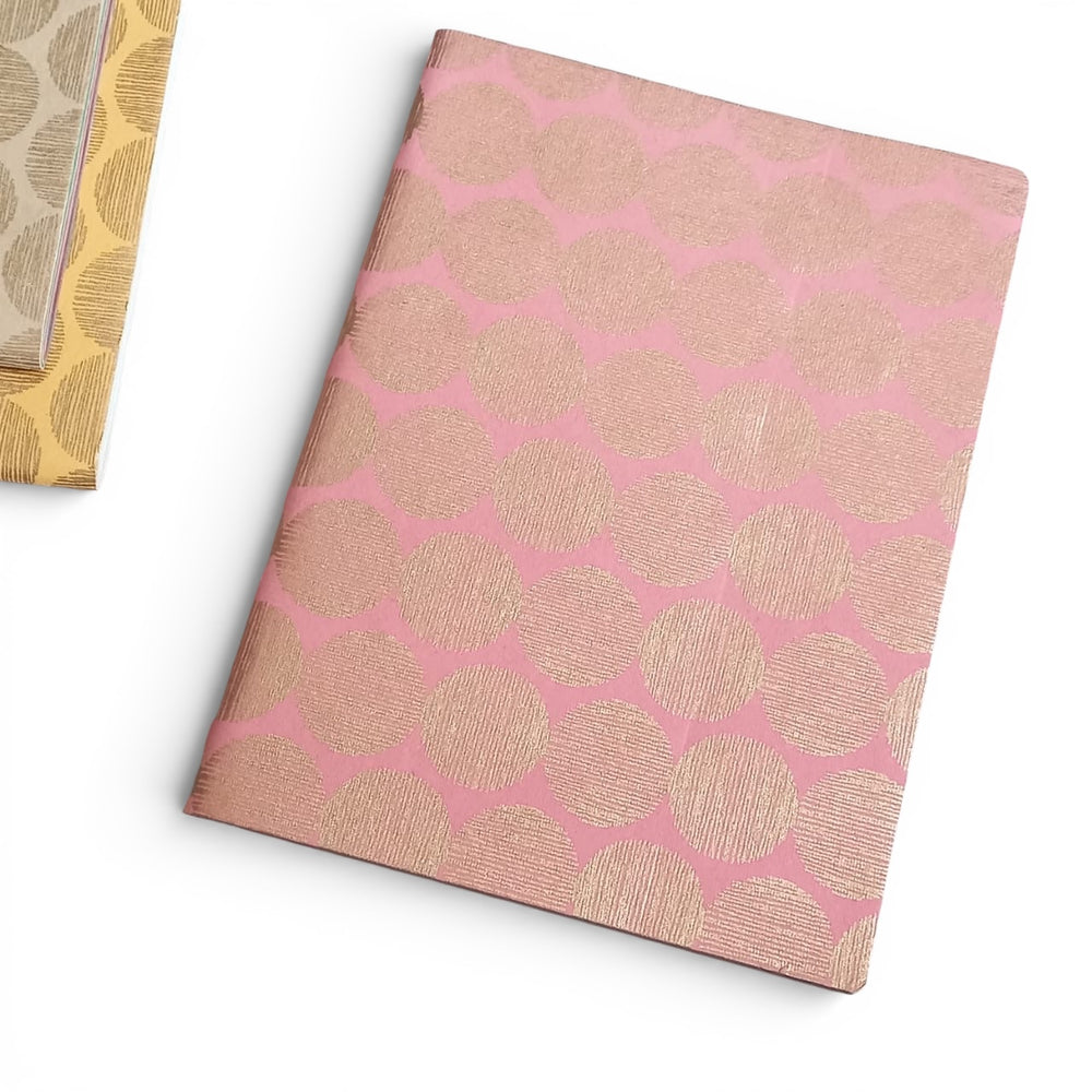 Handmade paper notebook with pink and gold sunrise geometric pattern on a white background