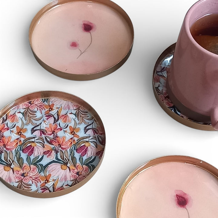 floral enamel coasters with a pink mug on a white surface