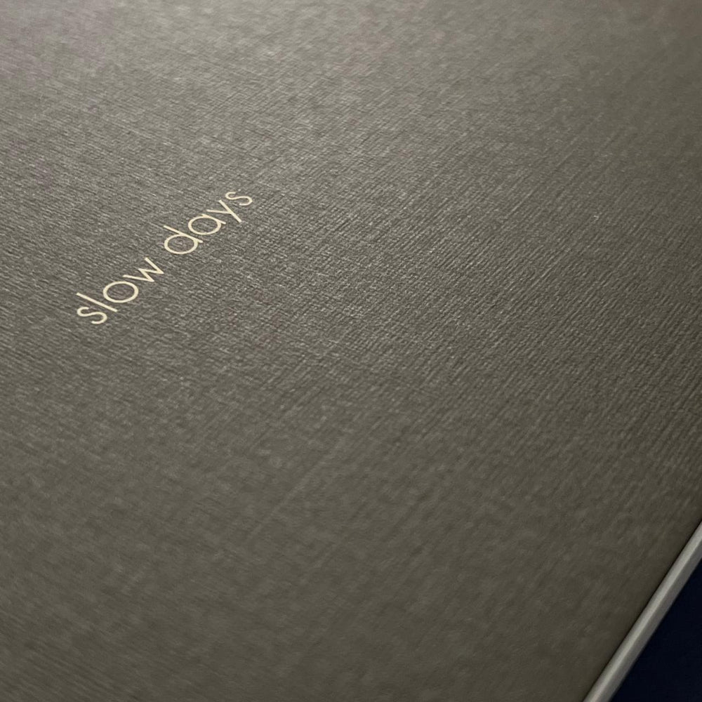 Textured paper with Slow Days screen printed on the cover. 