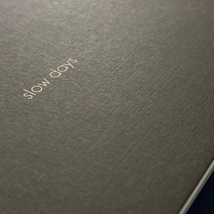 Textured paper with Slow Days screen printed on the cover. 
