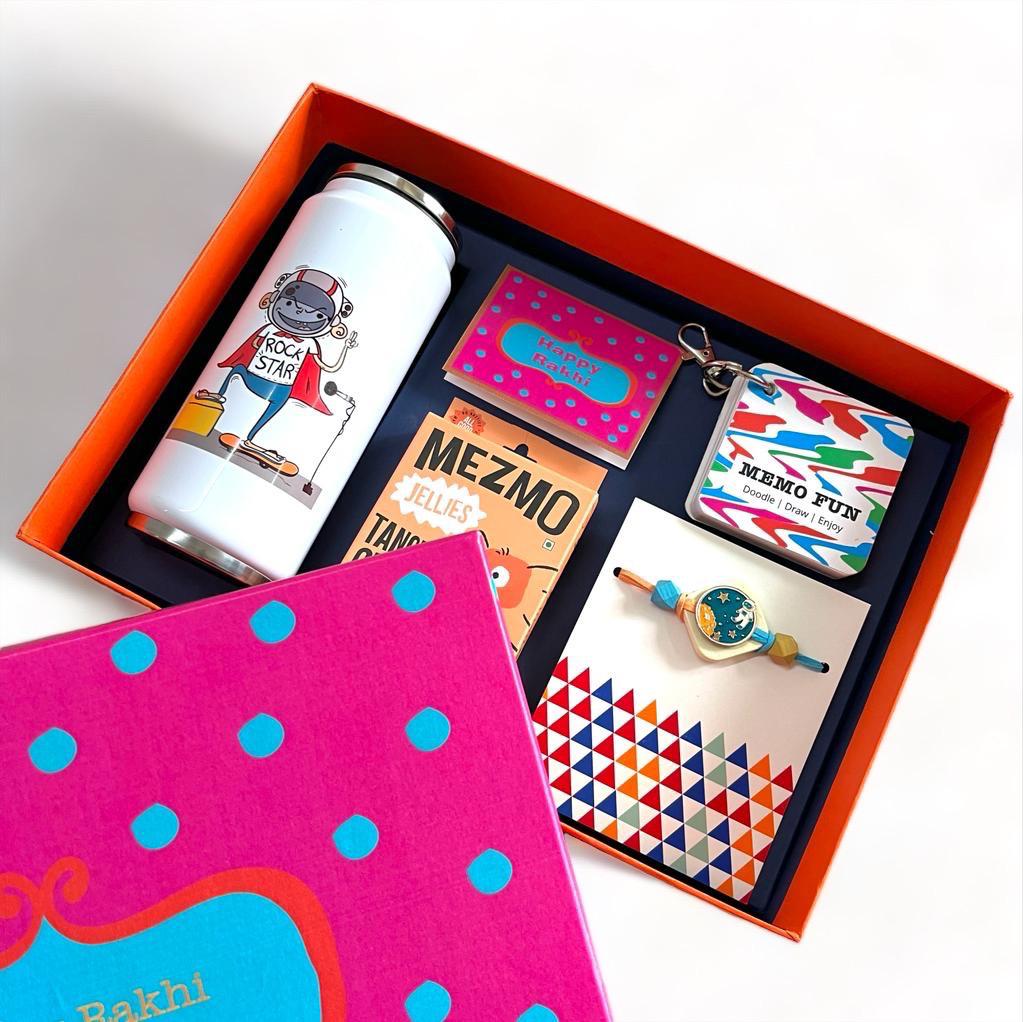 Gifts of Love Global Rockstar | Rakhi Gift Set _ Boxed gift with can sipper, memo fun notebook, astronaut rakhi, roli chawal and Mezmo Candy